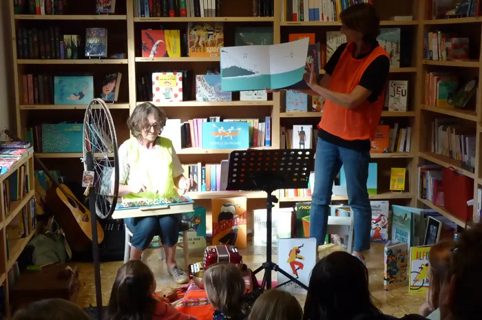 Des enfants sont en écoute tandis qu'on leur lit des livres sur les différents sports avec des animations musicales.