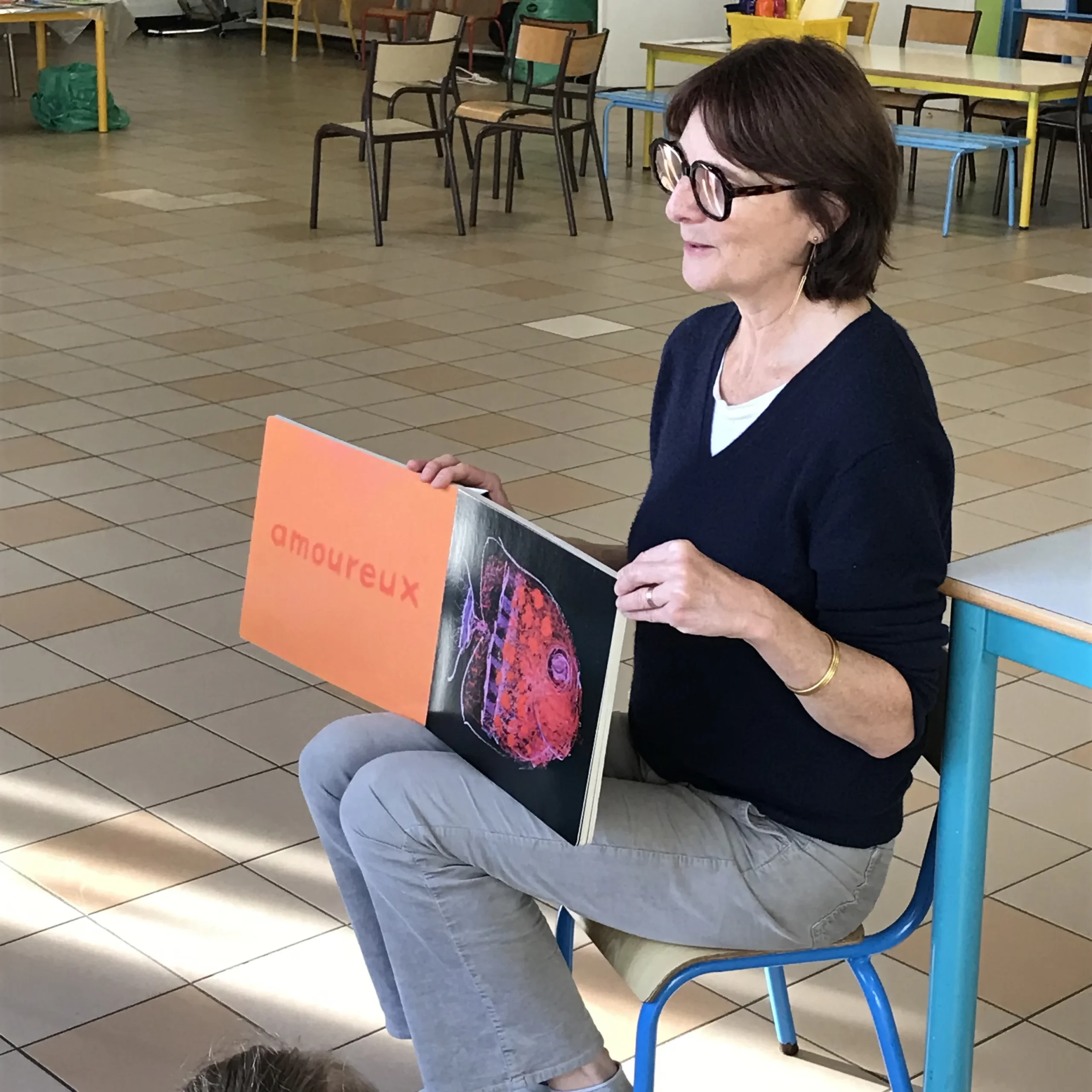 Laure Montaigne, médiatrice à Perluette en train de lire dans une classe de maternelle l'album "aujourd'hui je suis..?"