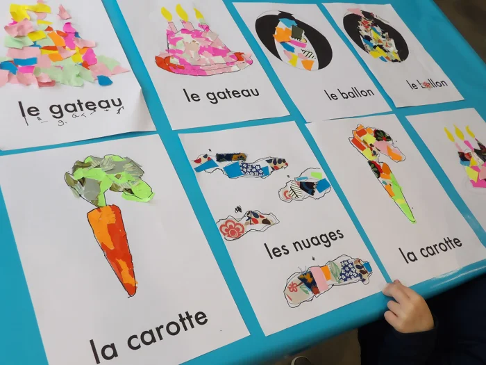 On voit les collages réalisés par les enfants sur "l'imagier" par Delphine Chedru. Les mots présents sur la page sont carotte, nuages, ballon, et gateau.