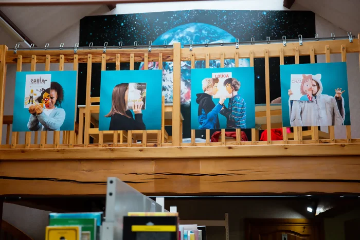 Les portraits de l'exposition Bookface de Perluette sont accrochés dans l'ancienne bibliothèque d'Orchies. Un bookface est un portrait ou le sujet tient en face de lui / elle un livre qui semble compléter son visage. Crédit photo : Kalimba