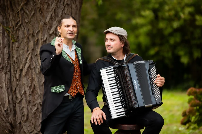 Photo paysage des conteur et accordéoniste dans le cadre des journées du patrimoine. Le conteur est en train de raconter une histoire, l'accordéoniste le regarde, assis sur un tabouret. Crédit photo : Kalimba