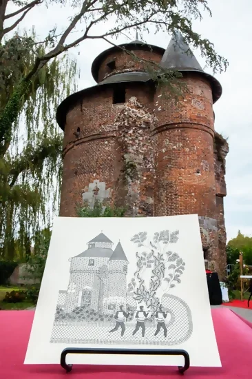 Vue de la Tour à Diable en contre-plongée, avec au premier plan un croquis en crayon très ressemblant de la tour qui sera ensuite mis dans une carte pop-up. Crédit photo : Kalimba.