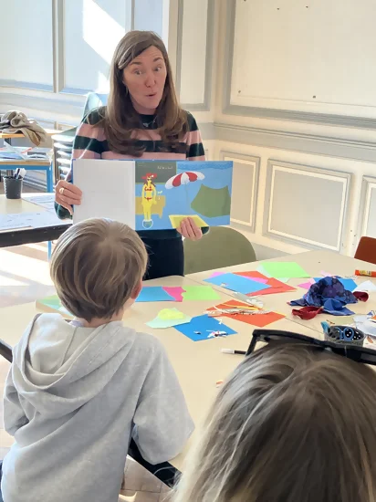 Une autrice est en train de lire son album devant des enants pendant un atelier en médiathèque