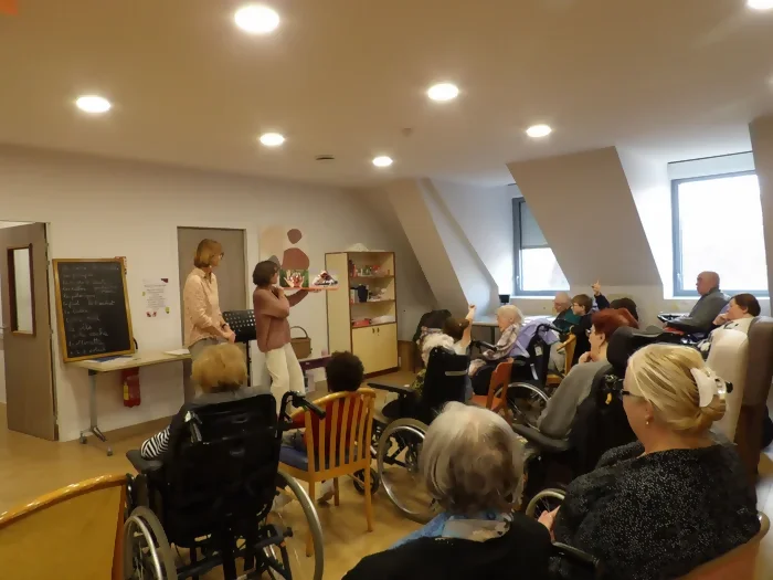Laure et Claire sont en train de faire une lecture animée à l'Ehpad Notre-Dame de Flandres. Les personnes âgées sont assises avec les enfants d'un centre de loisirs. C'est un projet intergénérationnel