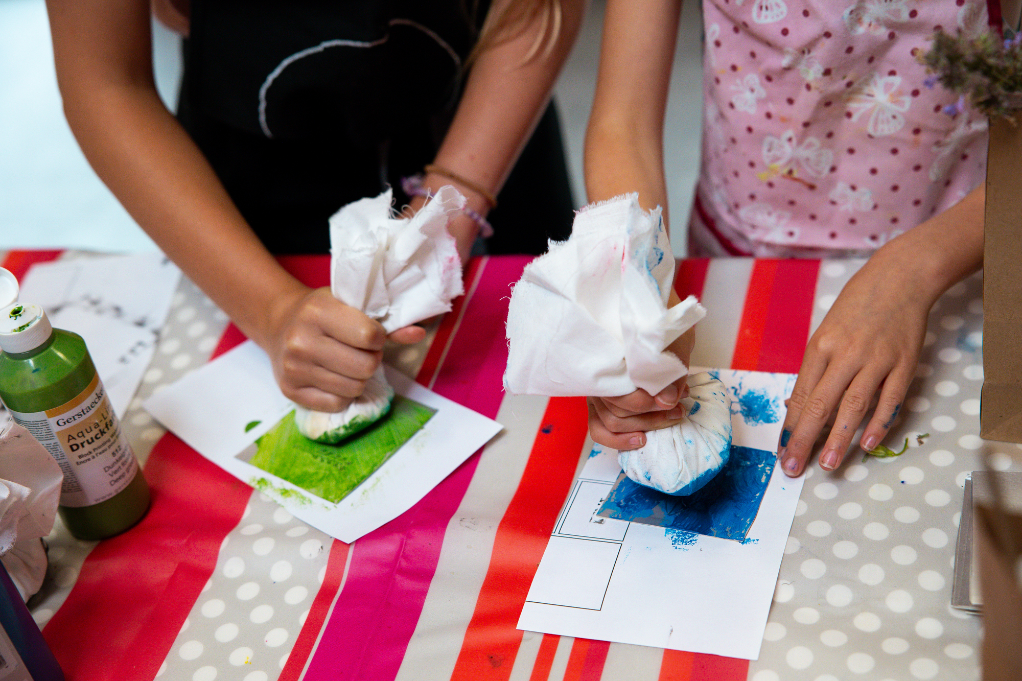 Atelier "Cueillette en liberté" : deux enfants tamponnent à la peinture leurs gravures sur emballages Tetra Pak.