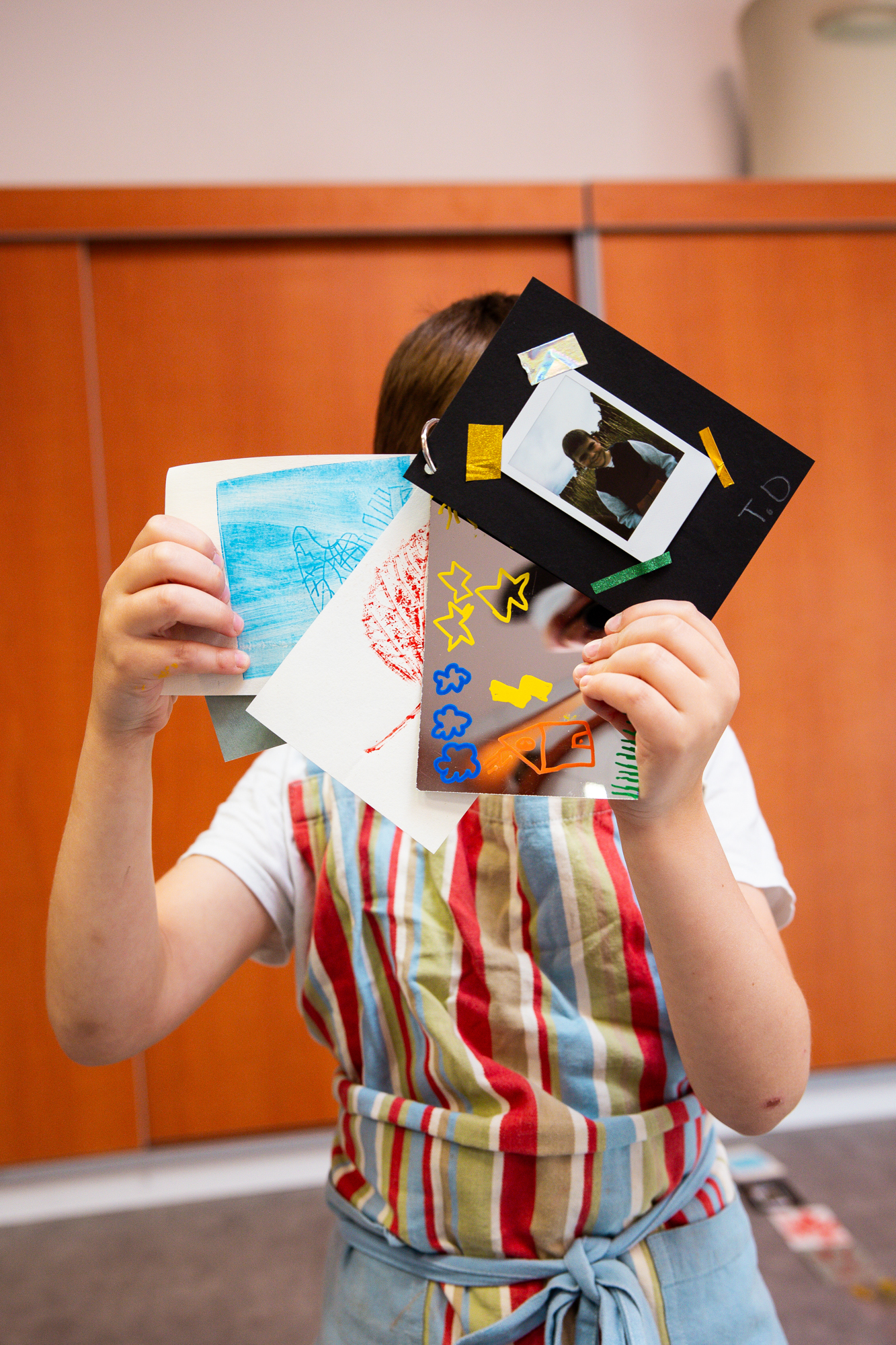 Un enfant déploie les pages de son carnet d'explorateur réalisé pendant l'atelier "Cueillette en liberté" proposé par Perluette.