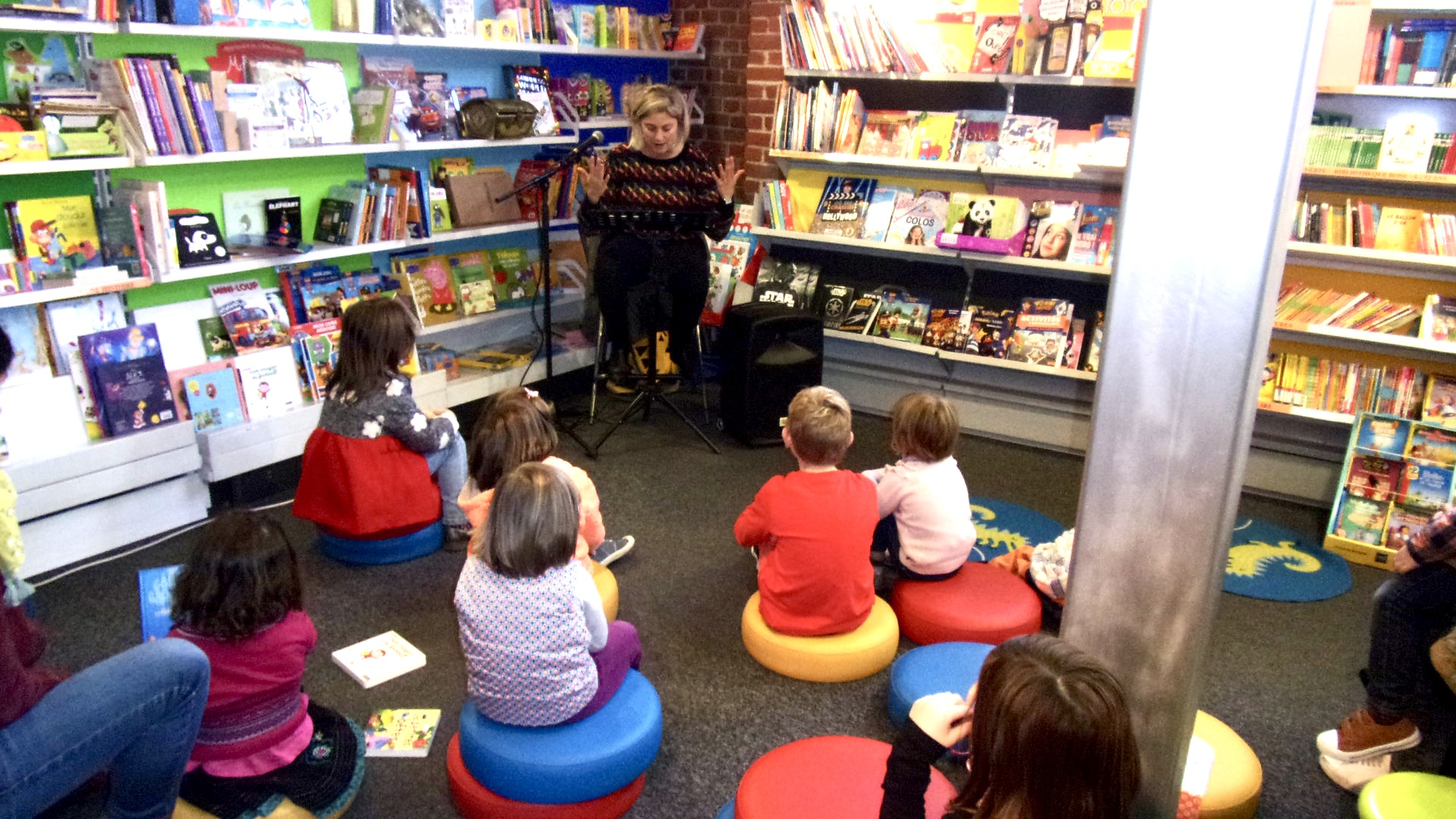 Lecture de la comédienne Sophie Descamps d'une histoire de la collection J'aime Lire - Editions Bayard face à un public d'enfants et parents dans une librairie.