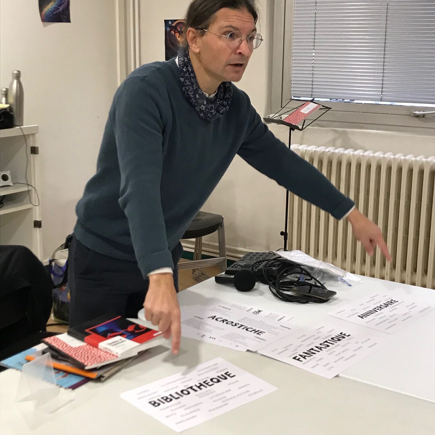 L'auteur conteur Thierry Moral présente les documents qui serviront à son atelier SLAM. On peut apercevoir quelques uns de ses ouvrages sur la table.